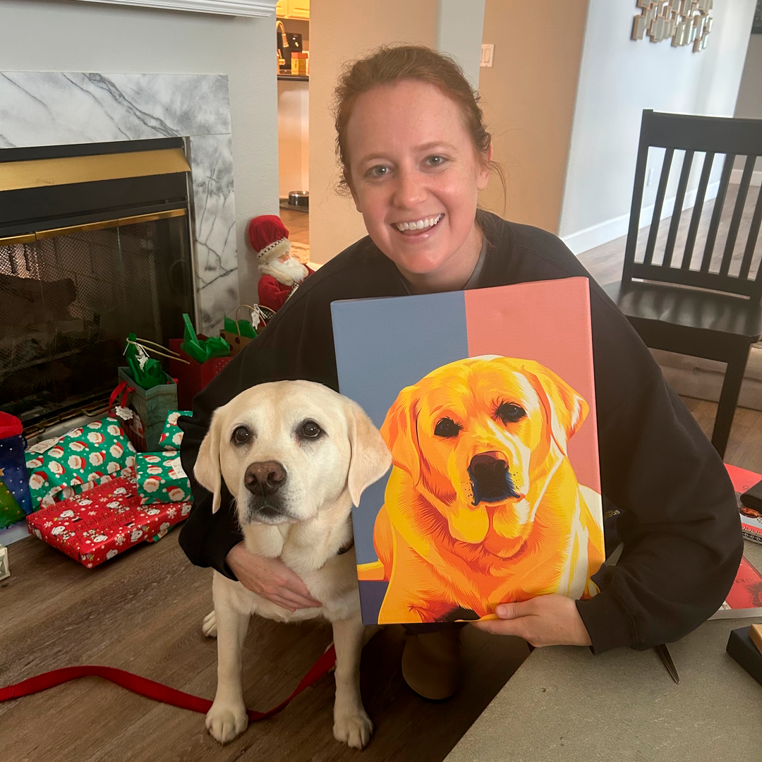 Person holding a painting of a dog next to a real dog in a festive living room.