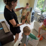 Woman and child in a living room with a large photo of a child and dog.