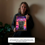 Person holding a framed picture of a dog named Billy with a colorful background.